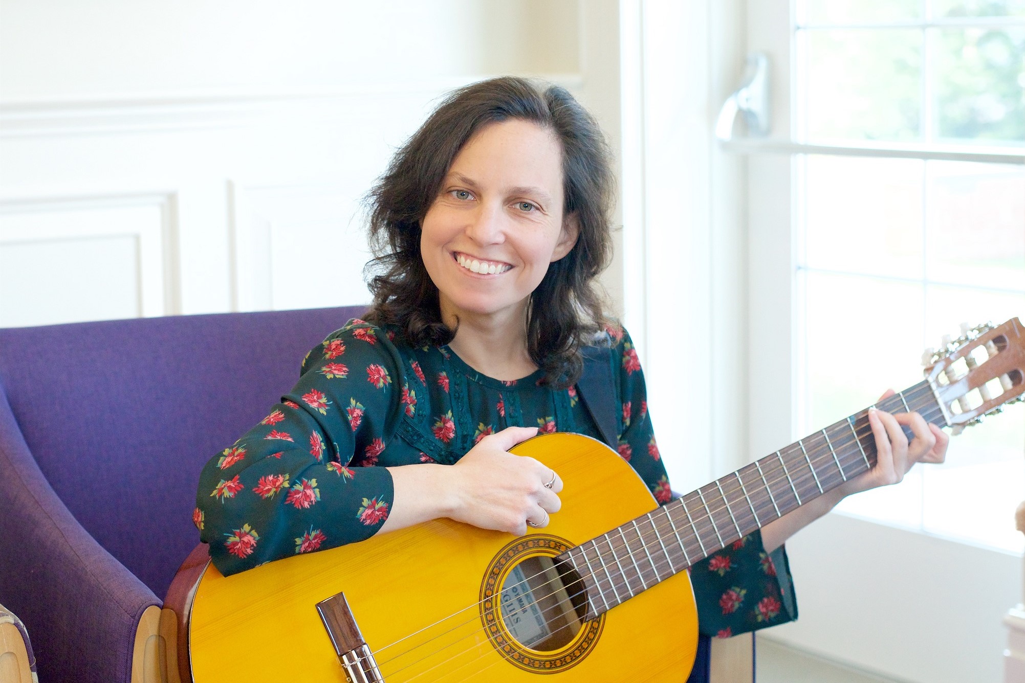 RVNAhealth Hospice Music Therapist Tammy Strom strums her guitar.