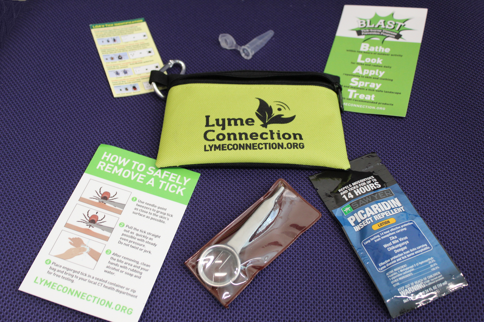 A lime-green pouch with the Lyme Connection logo, containing insect repellant, needle-point tweezers with a magnifying glass, a tick identification guide, a guide to safely removing a tick, a magnet with the BLAST protocol and a specimen vial to collect ticks.